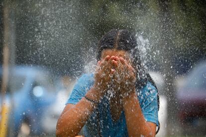 Una joven se refresca en una fuente de una calle de Córdoba, el viernes.