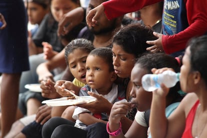 Un grupo de niños venezolanos come tras pasar dos días en el mar, en Trinidad y Tobago, el 24 de noviembre.