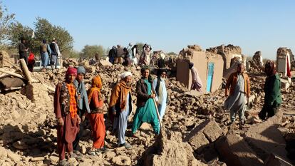 Un grupo de afganos, en medio de casas destruidas por el terremoto en el distrito de Zindah Jan, en la provincia de Herat, este domingo.