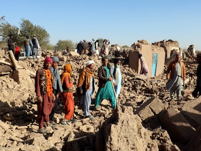 Un grupo de afganos, en medio de casas destruidas por el terremoto en el distrito de Zindah Jan, en la provincia de Herat, este domingo.