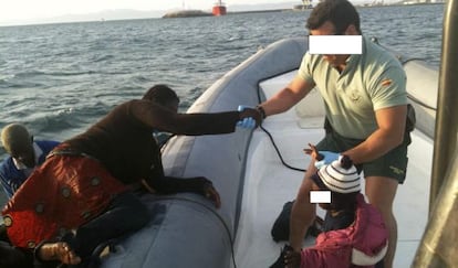 A Civil Guard officer helps a migrant aboard a patrol boat in Spanish waters. 