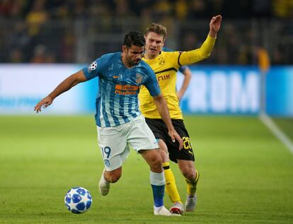 El delantero del Atlético de Madrid, Diego Costa, corre con el balón ante la presión del jugador del Borussia, Lukasz Piszczek.