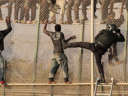 Un grupo de inmigrantes se enfrenta intenta sortear la valla de Melilla.