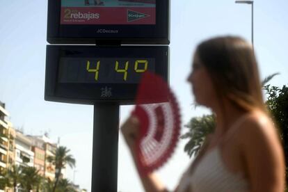 Una joven se abanica ante un termómetro que marca 44ºC debido a la llegada de la primera ola de calor del verano, en Córdoba.