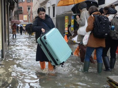 Turistas caminan por las calles inundadas de Venecia este viernes.