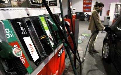 Una mujer carga el depósito de su vehículo en una gasolinera de Madrid