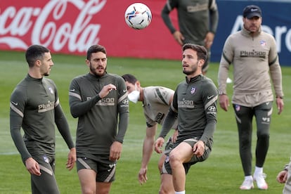 Mario Hermoso, Koke y Sául, dan toques a un balón bajo la atenta mirada de Simeone durante el último entrenamiento del Atlético previo al partido de este domingo ante el Sevilla en el Sánchez Pizjuán. / Chema Moya (EFE)