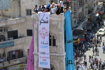 Un grupo de manifestantes despliega ayer en Hama una pancarta que dice "Gracias Al Yazira y SNN".