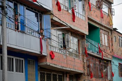 Residentes de un barrio en el sur de Bogotá despliegan trapos rojos en sus ventanas, una señal de alerta para pedir ayuda estatal.