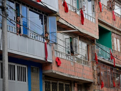 Residentes de un barrio en el sur de Bogotá despliegan trapos rojos en sus ventanas, una señal de alerta para pedir ayuda estatal.