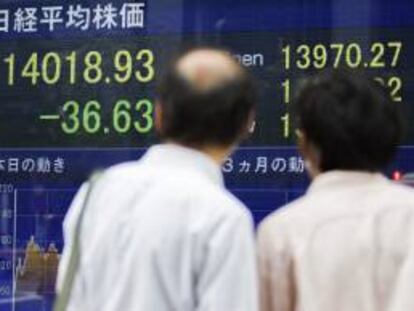 Empresarios japoneses miran una pantalla con los resultados de la bolsa de Tokio (Japón).
