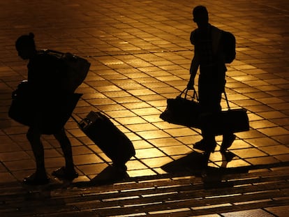 Dos migrantes venezolanos caminan con sus maletas, en febrero de 2021.