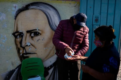 Un funcionario de casilla aplica gel antibacterial a los votantes que participan en la jornada electoral en el municipio de Chimalhuacán, Estado de México.