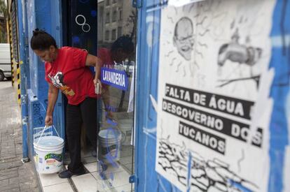 Funcionária de lavanderia busca água para ajudar a abastecer local.