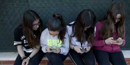 Un grupo de amigas adolescentes usando sus teléfonos móviles.