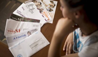 Una mujer indecisa en su voto mira los sobres de propaganda electoral recibidos de los principales partidos que se presentan a las próximas elecciones del 26 de junio.