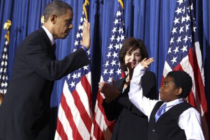 Obama choca su mano con la de Marcelas Owens tras la firma de la ley sanitaria.
