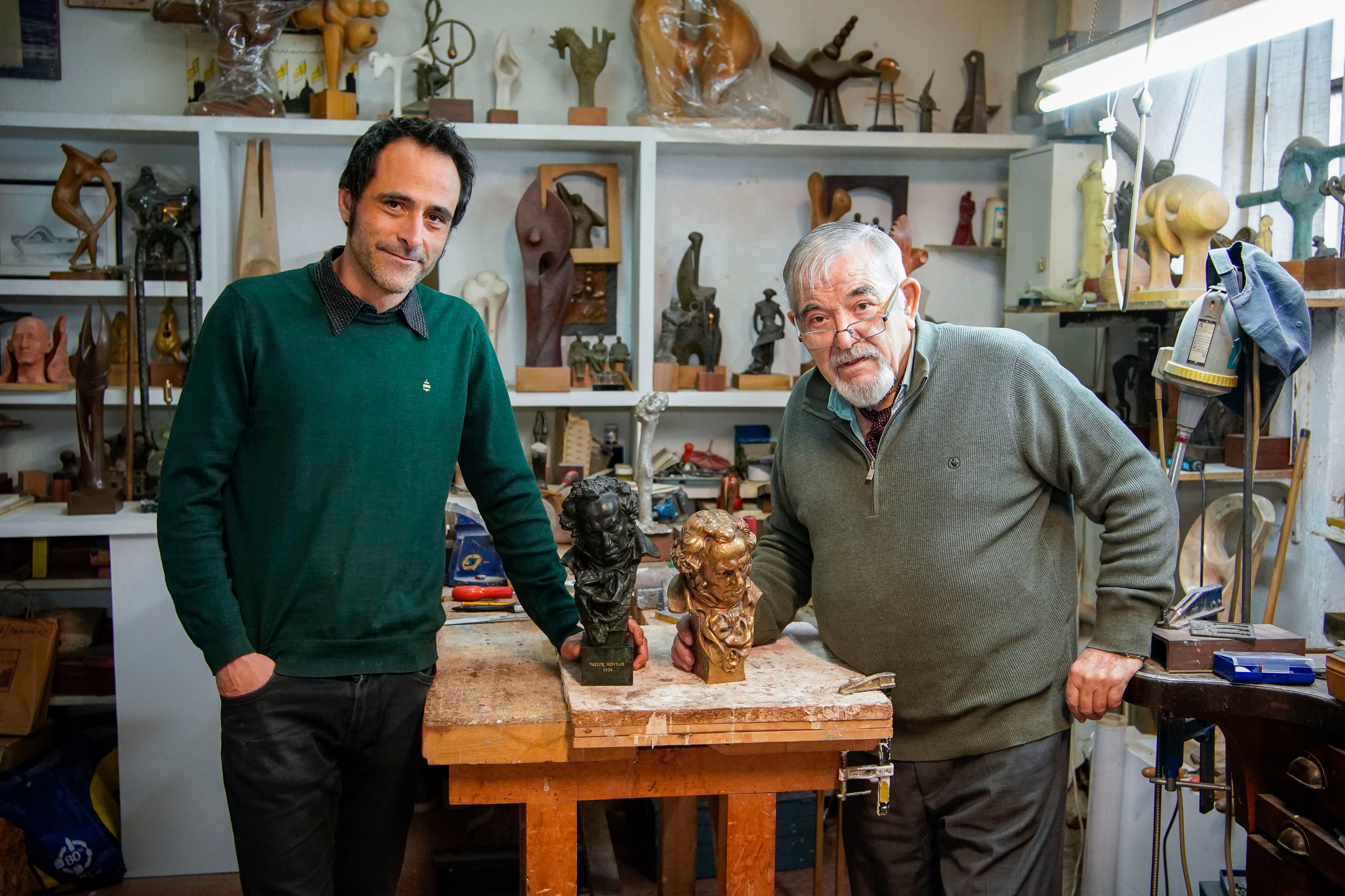Cristobal Fernández, ganador del Goya de montaje, izquierda, posa junto a su goya y su padre, José Luis Fernández, escultor y antiguo artesano de las figuras de los Goya, en el taller de este último en Madrid.
