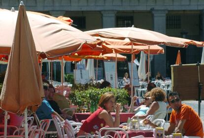 Un grupo de turistas disfruta de su tiempo libre en la madrileña plaza Mayor.