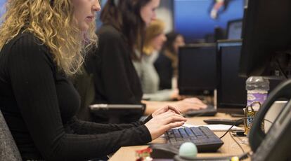 Una mujer joven en sus puesto de trabajo en una oficina.