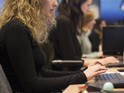 Una mujer joven en sus puesto de trabajo en una oficina.