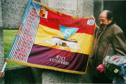 Enric Marco en 2003, cuando presidía la asociación Amical de Mauthausen, junto a una bandera alusiva a los exterminios nazis.