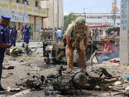 Fuerzas de seguridad somalíes examinan el lugar en Mogadiscio en el que al Shabab explotó un coche bomba en julio.