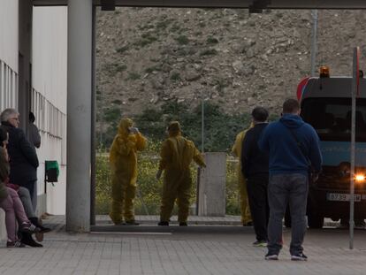 Varios operarios con trajes protectores, en el acceso de urgencias del Hospital Universitario Infanta Elena de Valdemoro, este domingo.