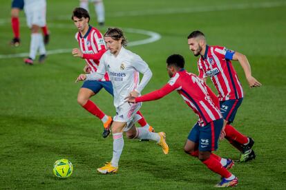 Luka Modric conduce el balón rodeado por tres jugadores del Atlético durante el derbi de este sábado.