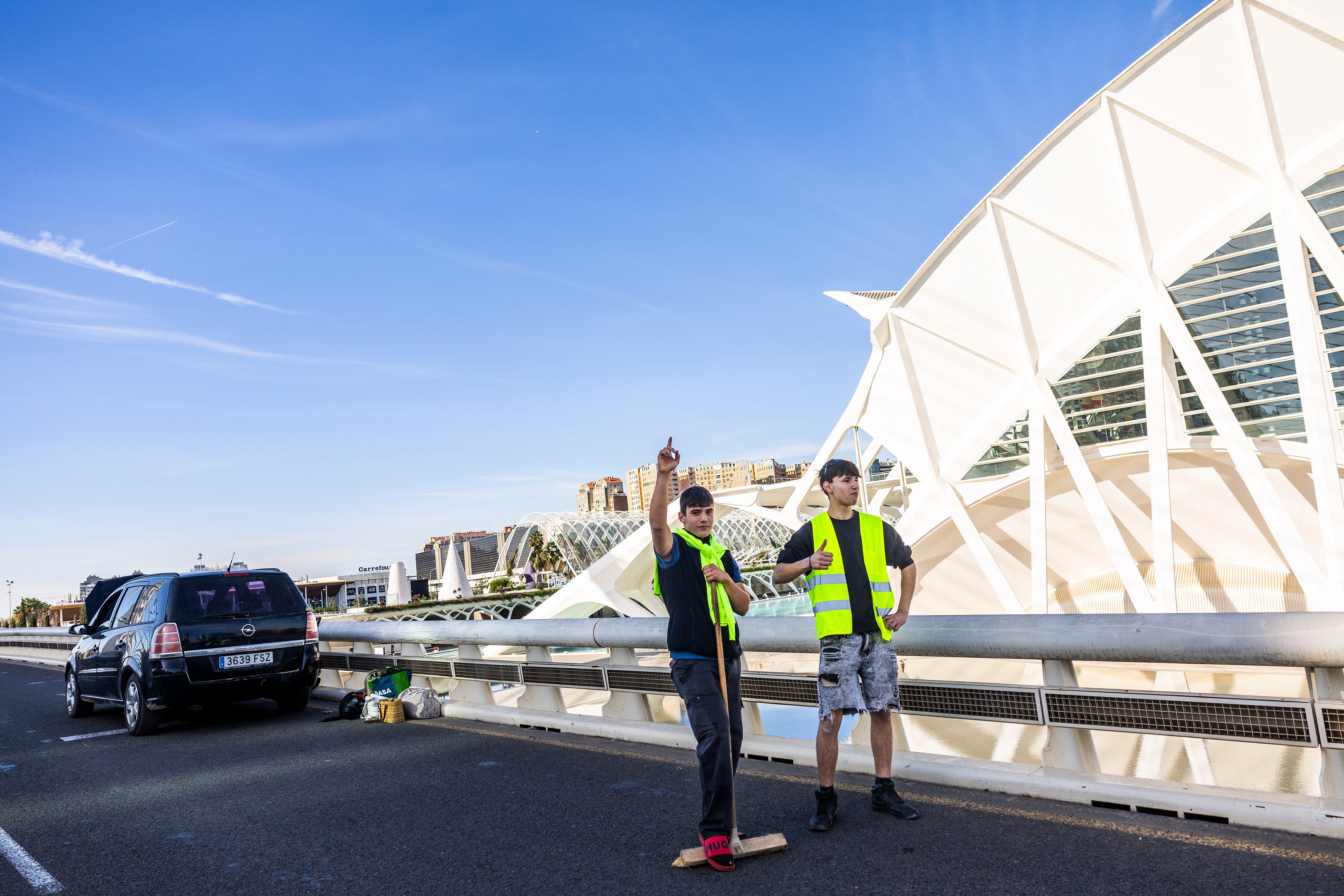 Dos jóvenes voluntarios con el coche estropeado en mitad del puente l'Assut de l'Or de Valencia.