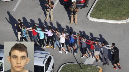 Estudantes escoltados deixam o instituto. À esquerda, a imagem de Cruz