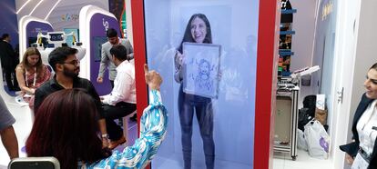 La asistente holográfica dotada con inteligencia artificial muestra a una visitante el dibujo que ha hecho de ella.