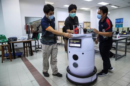 Profesores de ingeniería debaten junto a su prototipo de robot medicalizado 'IIUM Medibot V2' que permitirán a los doctores monitorizar pacientes con COVID-19 en la Universidad Internacional Islámica en Gombak, a las afueras de Kuala Lumpur (Malasia).