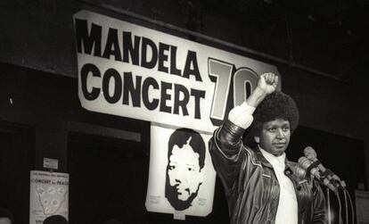 Winnie Mandela saluda con su puño en alto tras anunciar un concierto por el 70 cumpleaños de su marido, Nelson Mandela, en 1988.