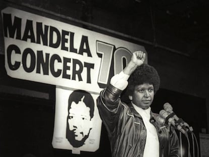 Winnie Mandela saluda con su puño en alto tras anunciar un concierto por el 70 cumpleaños de su marido, Nelson Mandela, en 1988.