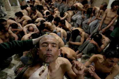 Un detenido era afeitado en un campo de tratamiento de drogas en Kabul mientras otros arrestados esperaban su turno, el 31 de mayo.