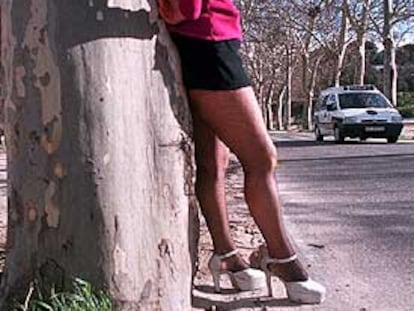 Una prostituta ofrece sus servicios, vigilada por un coche de la policía, en la Casa de Campo.