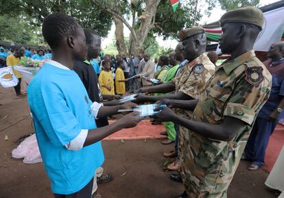 Soldados entregan material escolar a niños desmovilizados de las milicias.