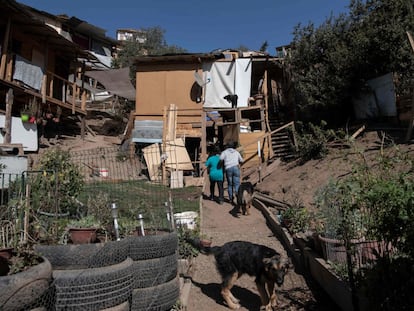 Una pareja ingresa a su casa en el campamento Toma la Cancha, en la comuna Lo Barnechea, en Santiago.