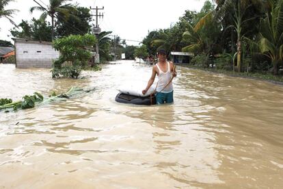 Un aldeano se abre paso por una carretera inundada en Karawang, en Java Occidental (Indonesia).