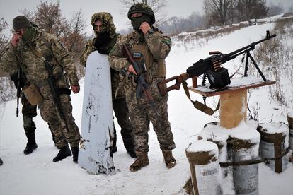 Varios militares ucranios posan el pasado 16 de diciembre junto a los restos de un misil que aseguran haber derribado con la ametralladora de la foto junto a una de las centrales que abastece de energía Kiev.