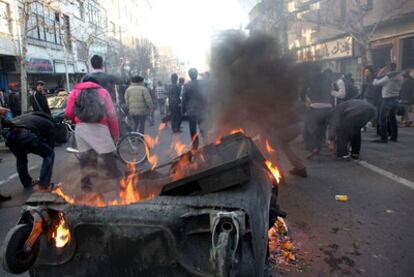 Un contenedor de basura arde en el centro de Teherán durante una protesta antigubernamental.