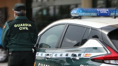 Un agente de la Guardia Civil junto a un vehículo del cuerpo.