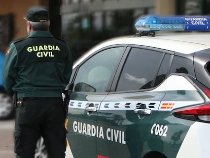 Un agente de la Guardia Civil junto a un vehículo del cuerpo.