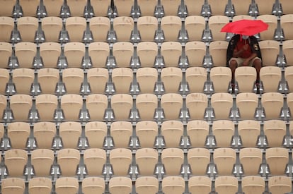 Un espectador del Roland Garros espera la reanudación de un partido suspendido por la lluvia, en París, Francia.