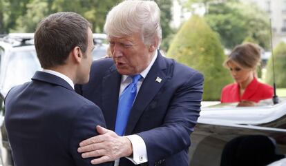 El presidente francés, Emmanuel Macron (izquierda), recibe al estadounidense, Donald Trump, con la primera dama estadounidense Melania al fondo.