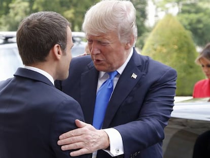 El presidente francés, Emmanuel Macron (izquierda), recibe al estadounidense, Donald Trump, con la primera dama estadounidense Melania al fondo.