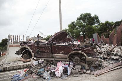 Un coche destruido por escombros de una casa en Pedernales, el 17 de abril de 2016.
