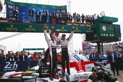 Fernando Alonso, Kazuki Nakajima y Sebastien Buemi, celebran la victoria subidos en su coche Toyota TS050, en Le Mans.