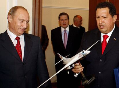 El presidente venezolano, Hugo Chávez, sostiene la maqueta de un bombardero ruso bajo la mirada del primer ministro ruso, Vladímir Putin.